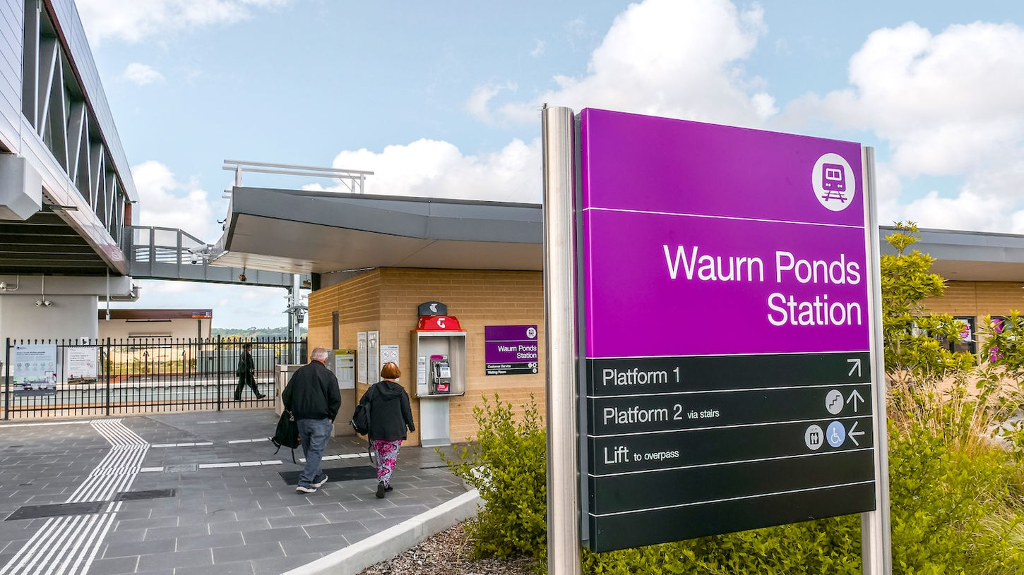 Waurn Ponds train station platform with purple signage and landscaped surroundings